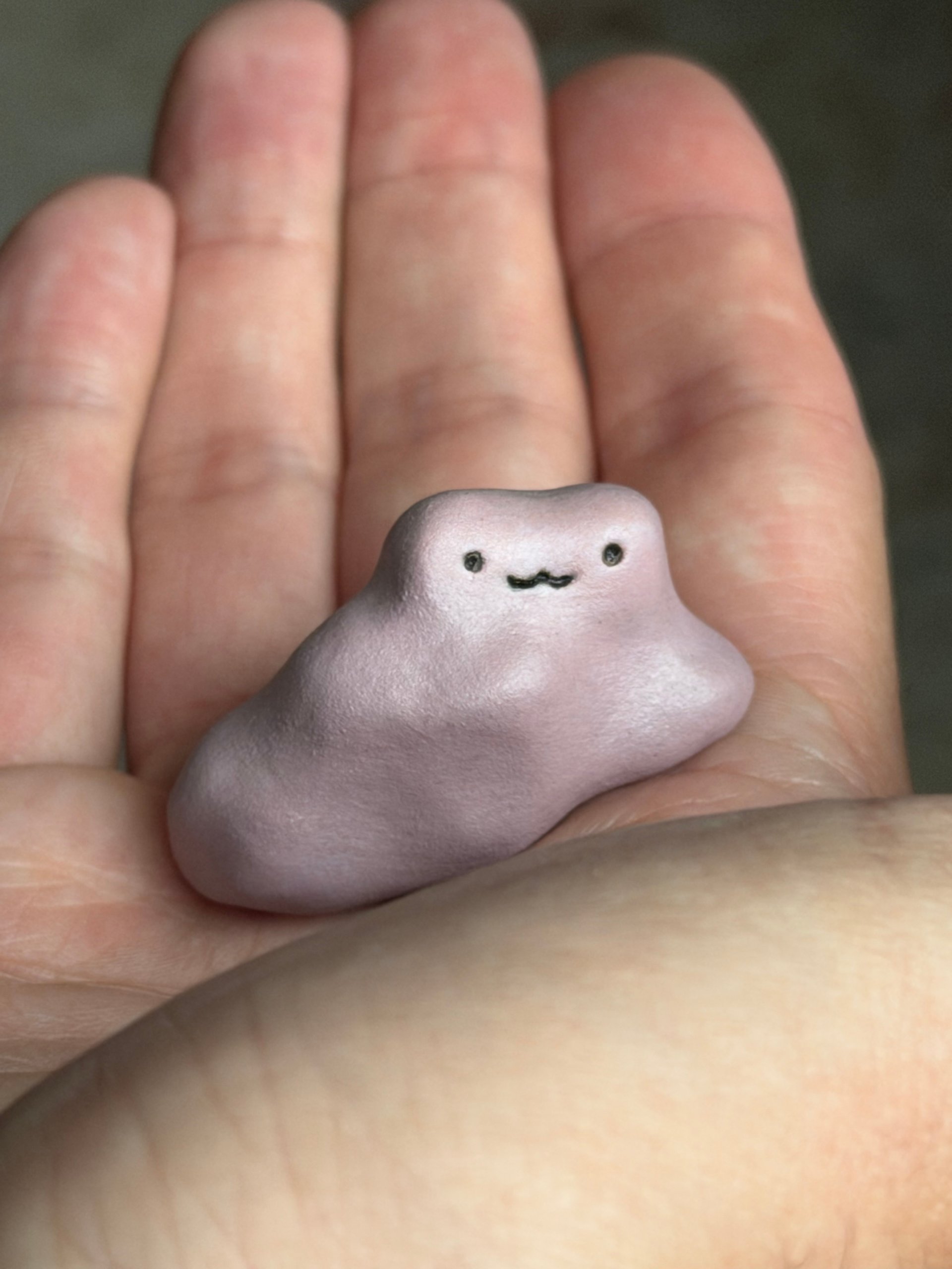 The same frog held in an open palm, showing how small it is