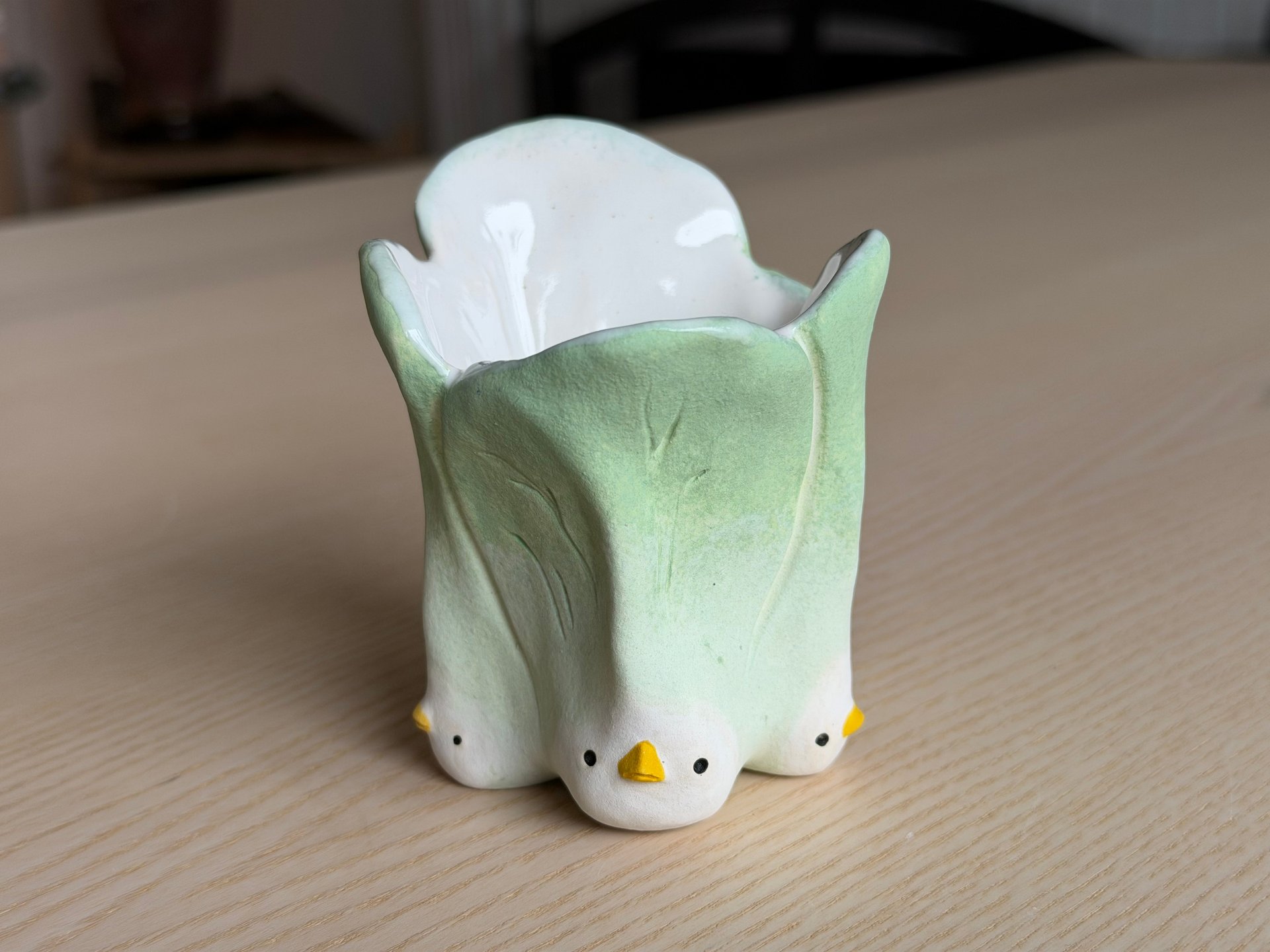 A vessel shaped like a head of bok choy, pale green leaves standing up from a white base