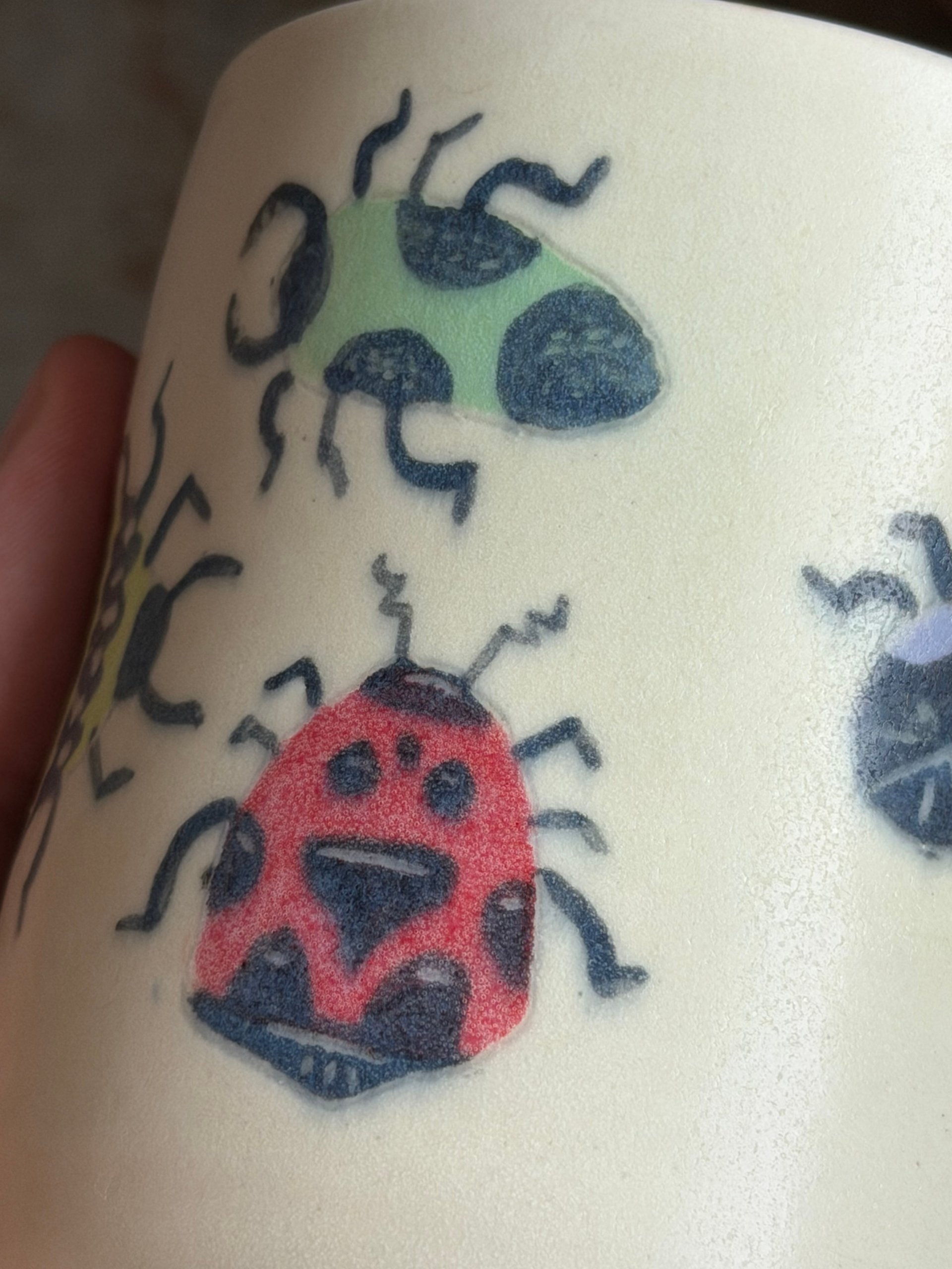 Close view of the red ladybug and a green beetle painted on the surface