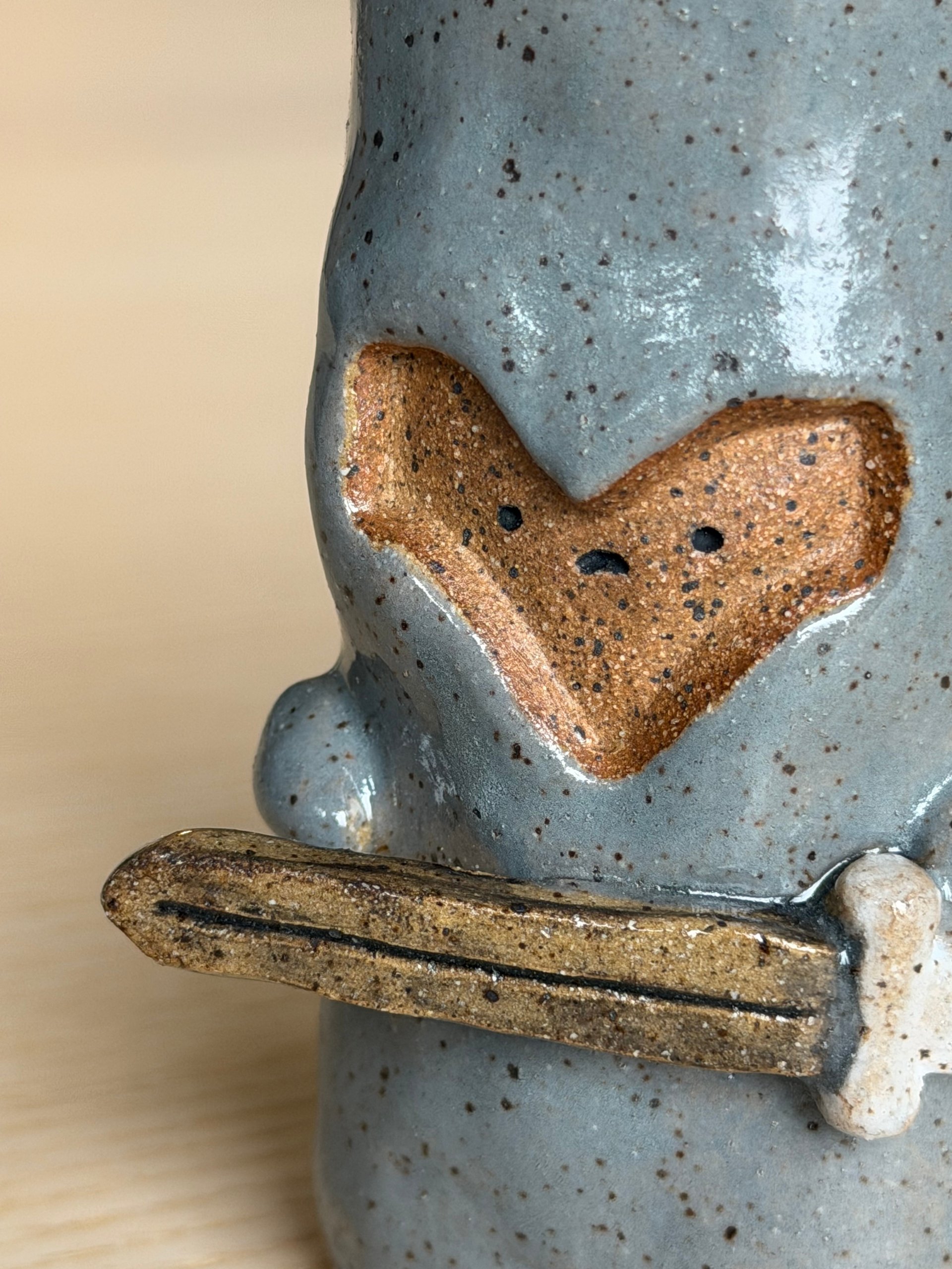 The heart-shaped face above the sword held across its body