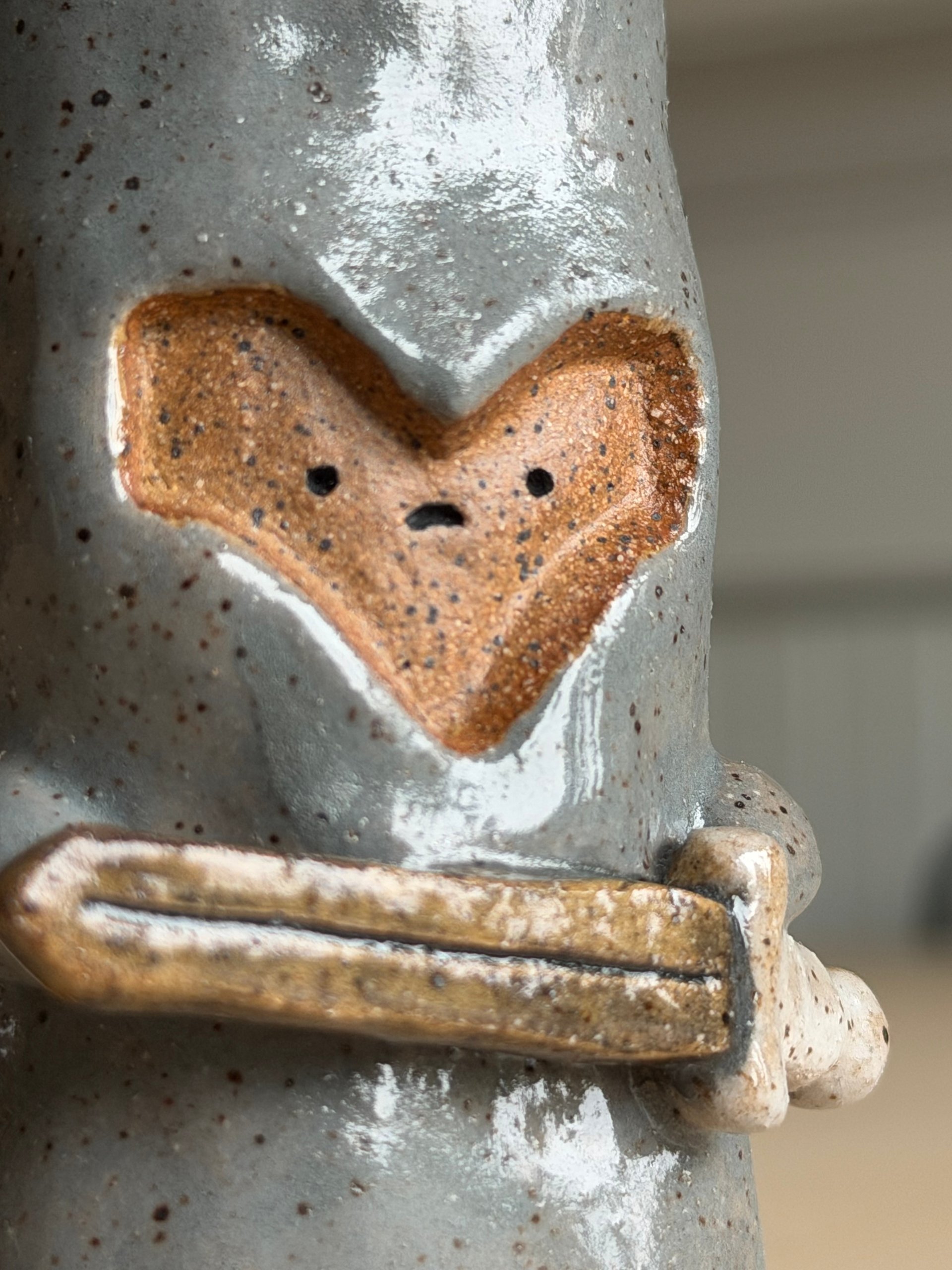 The face at an angle, sword crossing beneath it