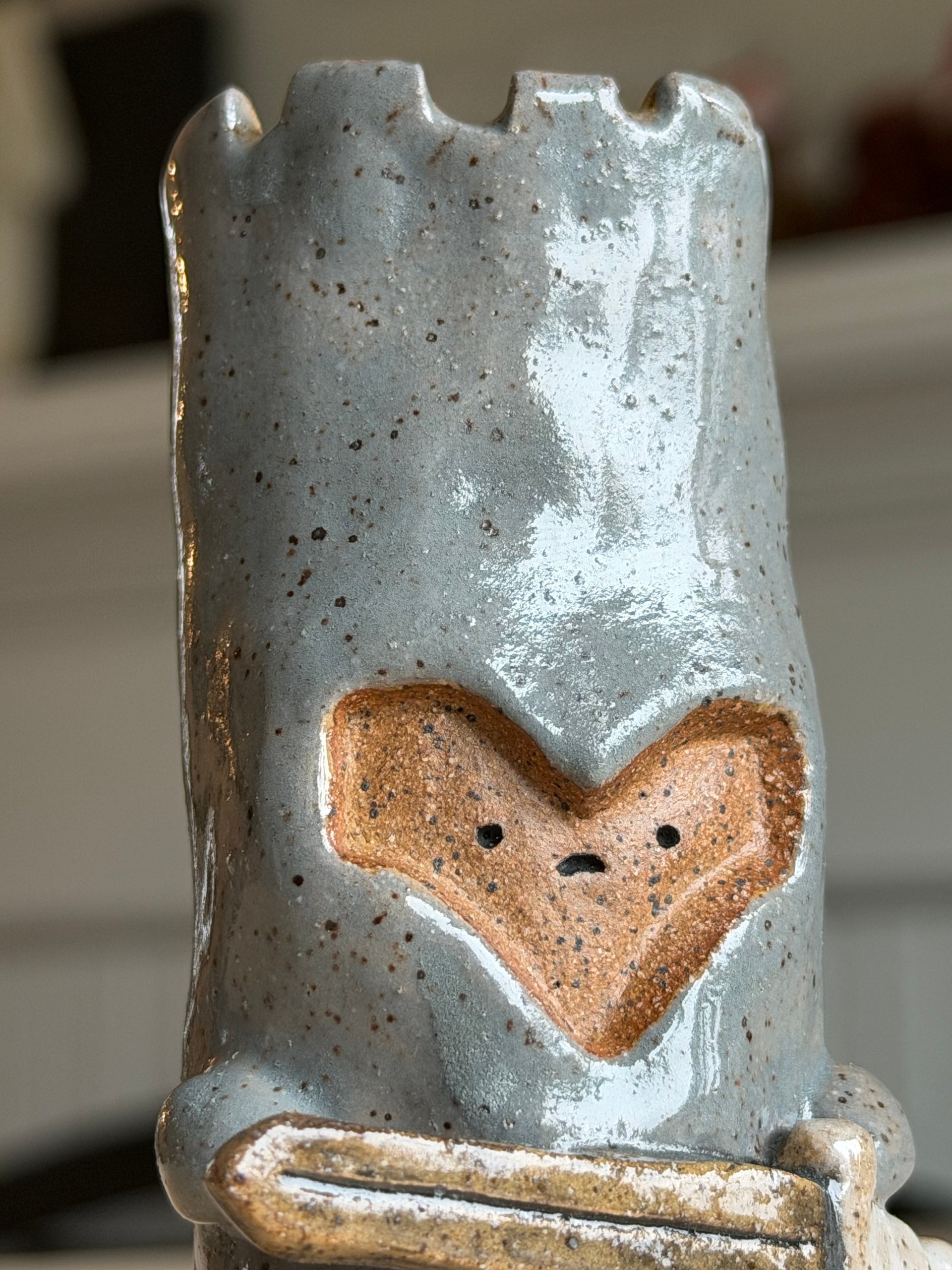 Closer on the heart-shaped face and the notched battlements above it