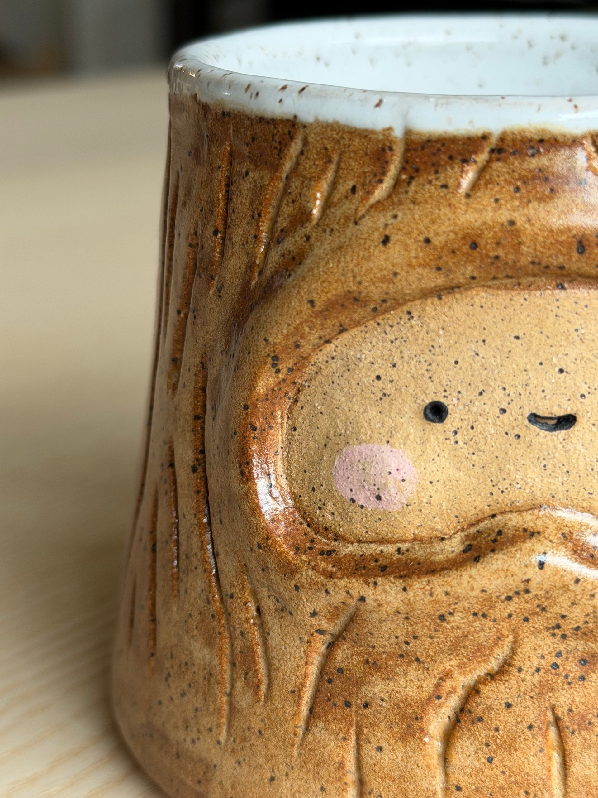 The honey mug's face, with a pink nose and closed eyes