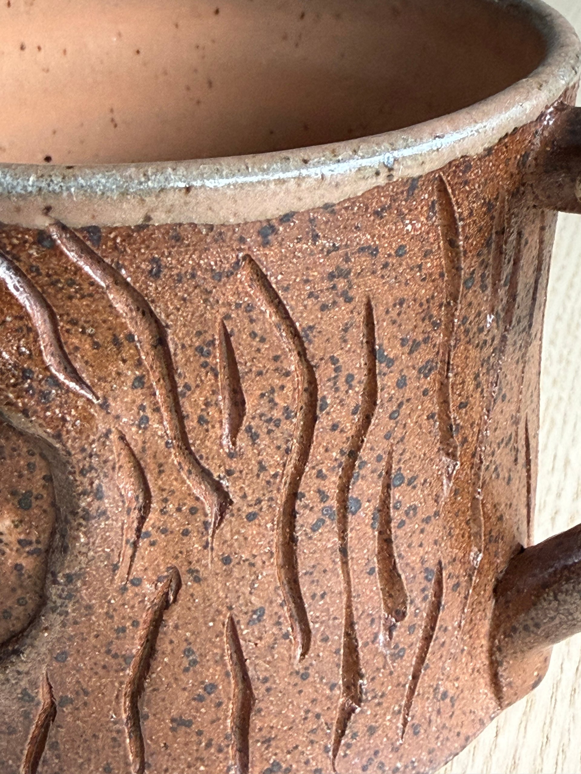 Close view of the carved bark texture and speckled glaze