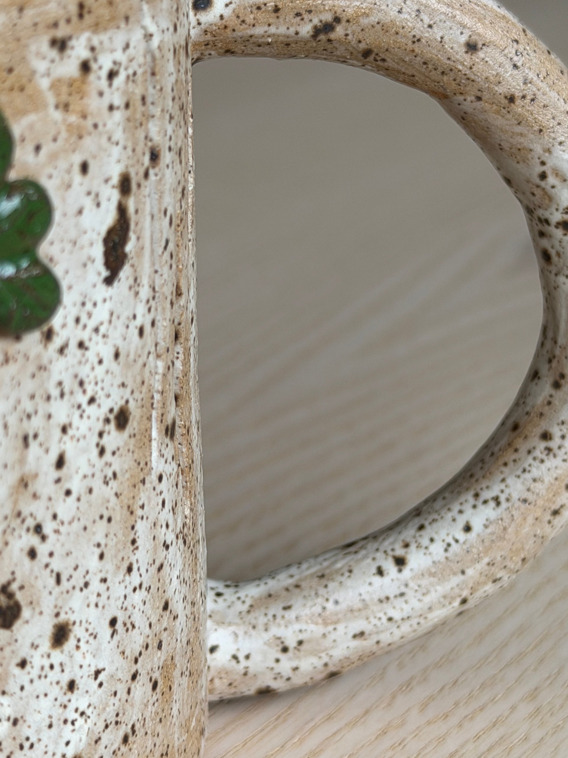 Ivy leaves climbing the branch handle of the pale mug
